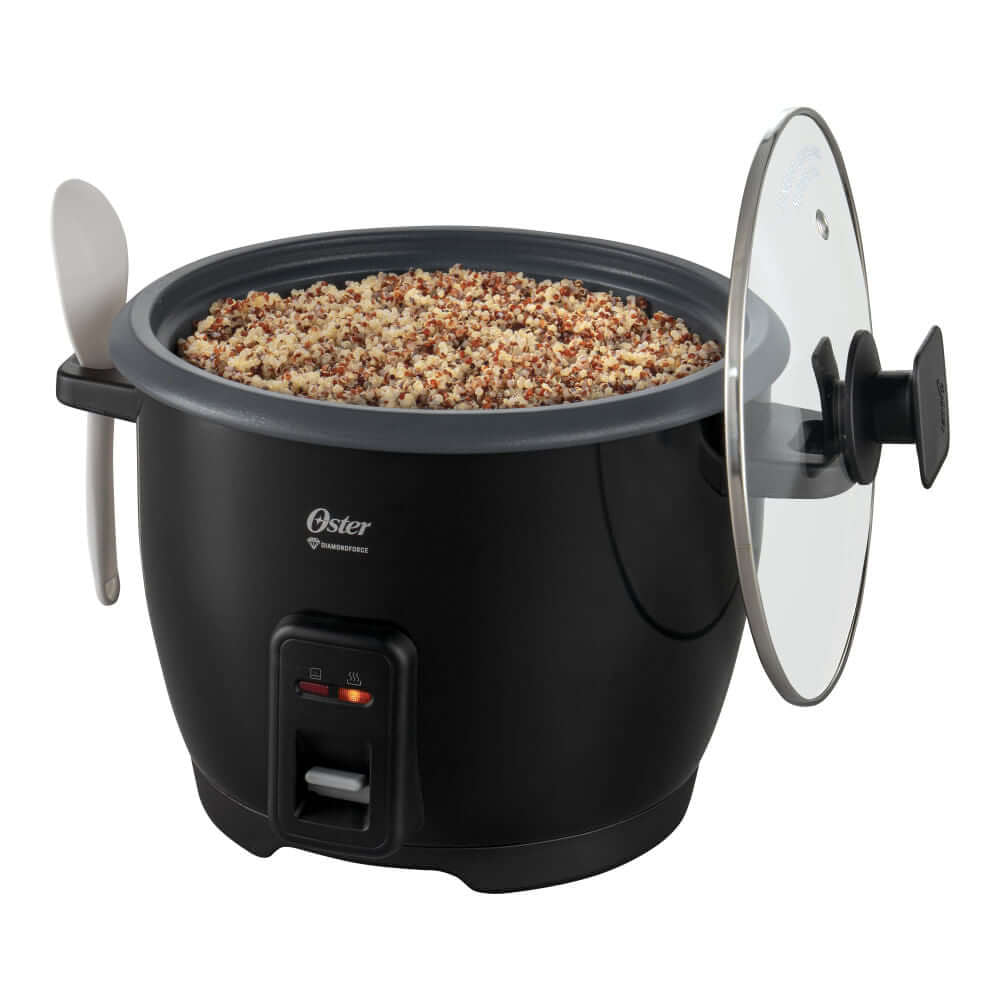 Arrocera eléctrica OSTER 10T negra cocinando arroz con tapa y cuchara, ideal para familias.