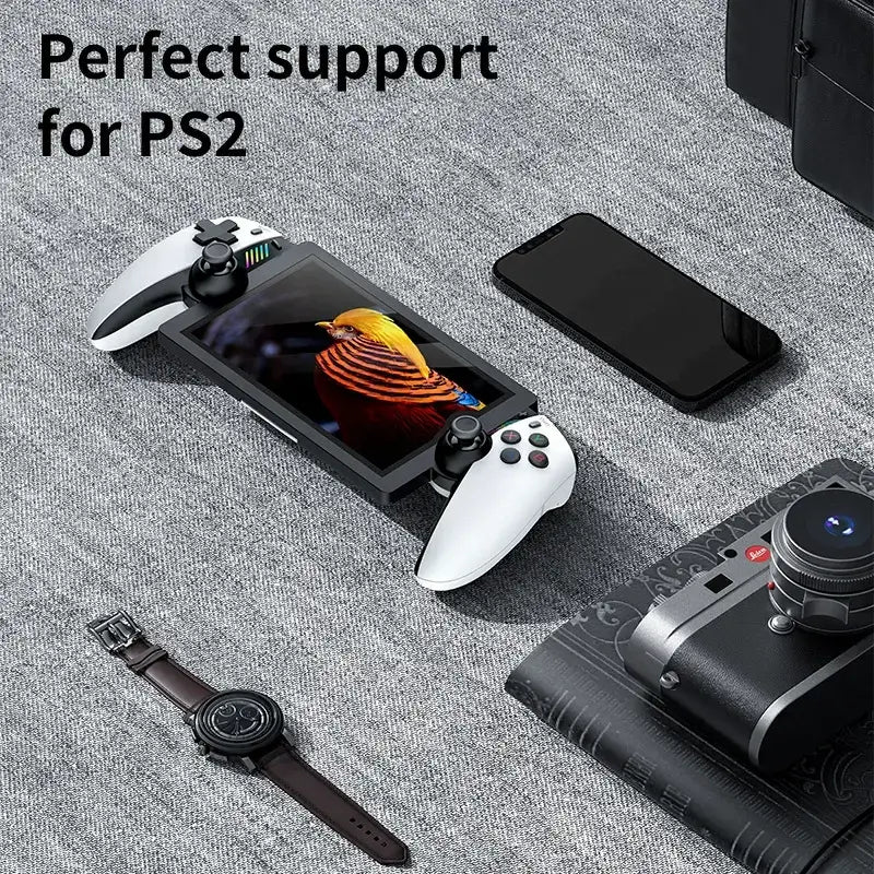 Consola de juegos portátil PS2 M28 con control y smartphone en mesa, ideal para gamers.