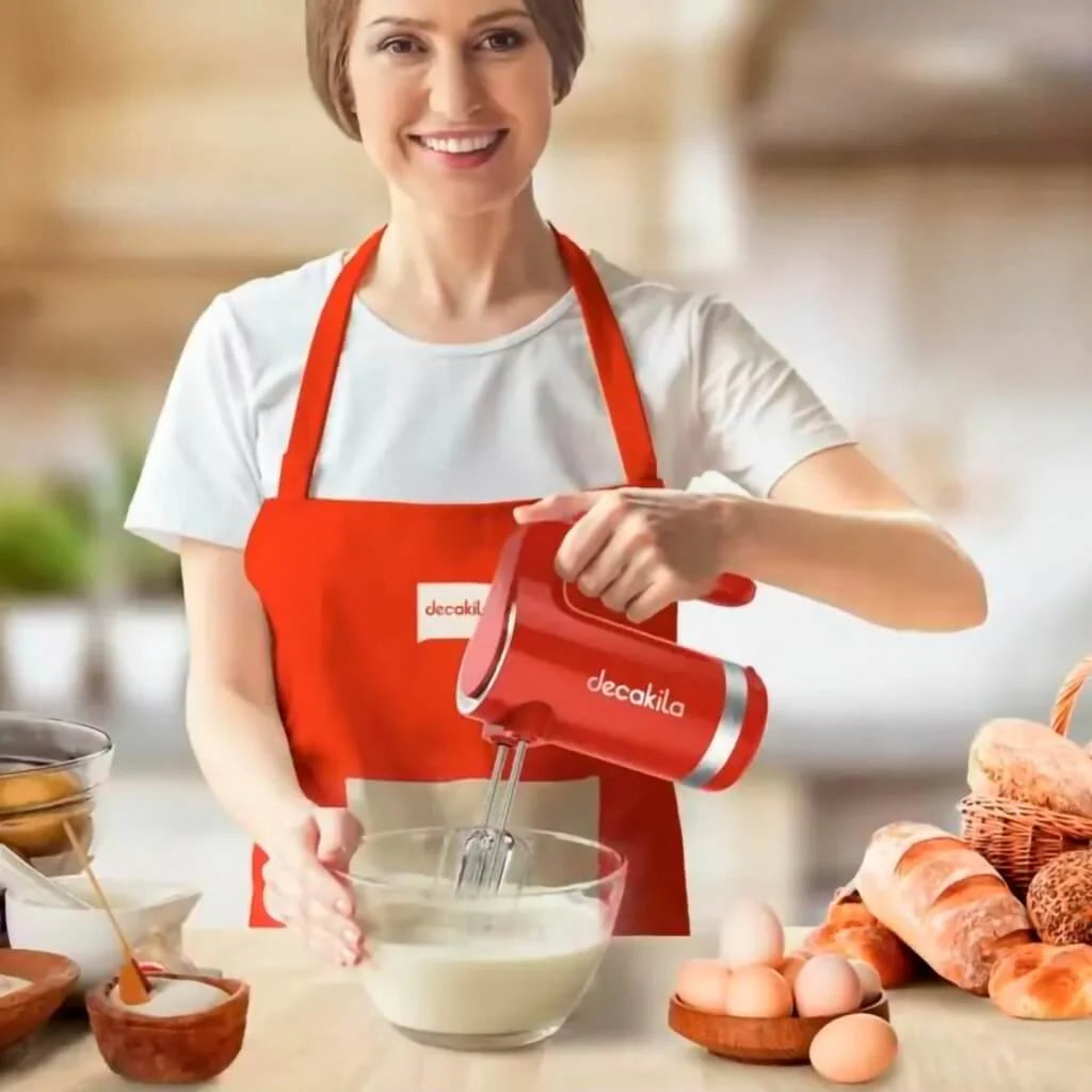 Persona usando batidora de mano Decakila roja en cocina con ingredientes para hornear.