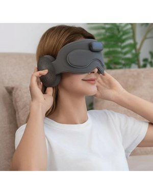 Mujer usando máscara de relajación con monitoreo de sueño y auriculares Bluetooth para aliviar el estrés.