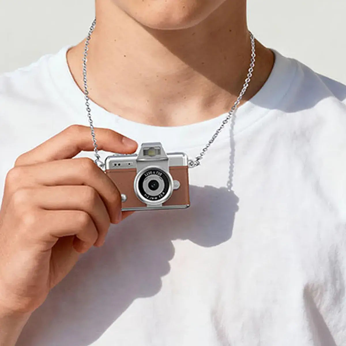 Mini cámara digital llavero 1080P colgada del cuello de una persona, ideal para capturar momentos.