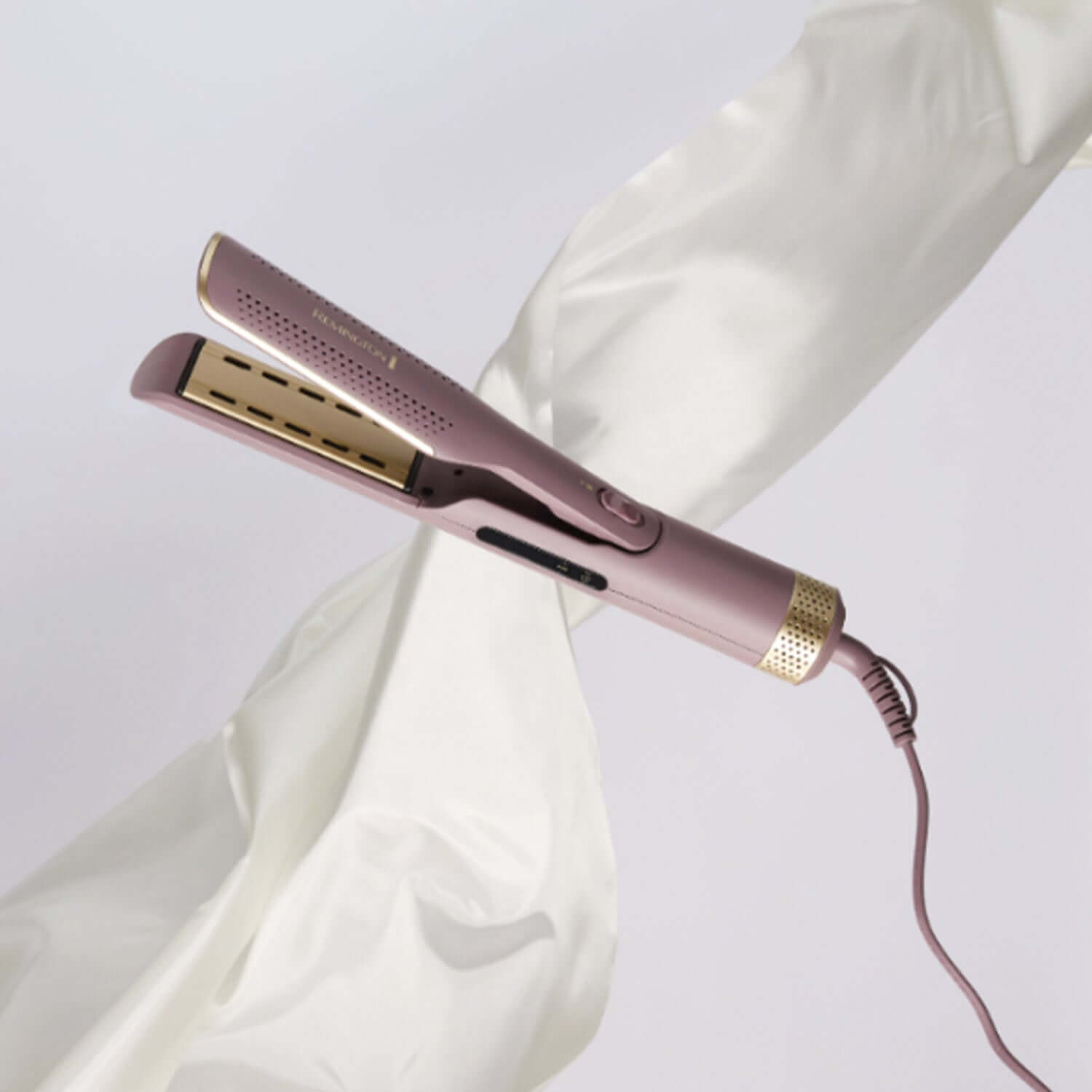 Estilizador y plancha 2 en 1 Remington en color rosa sobre fondo blanco.